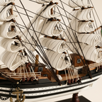 Close-up detail of Amerigo Vespucci Italian Navy tall ship wooden model showing dense black rope rigging knots, white square-rigged sail texture, wooden yard arms, black-and-white striped hull with white dot trim, and gold AMERIGO VESPUCCI nameplate on black display base