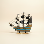 Modello in legno di nave pirata, vista laterale, con tre alberi, vele nere con teschio, scafo a righe blu e base nera