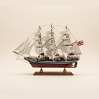 Modello in legno del clipper britannico Cutty Sark 1869, vista laterale, con tre alberi, vele quadre bianche, scafo blu navy e bandiera Union Jack