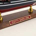 Modello in legno del clipper britannico Cutty Sark 1869, dettaglio ravvicinato, con tre alberi, vele quadre bianche, scafo blu navy e bandiera Union Jack