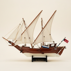 Kuwait Dhow wooden ship model perfect side profile view showing full silhouette, white lateen sails, mahogany hull, rope rigging, and black display stand, 40 cm length, cream white background