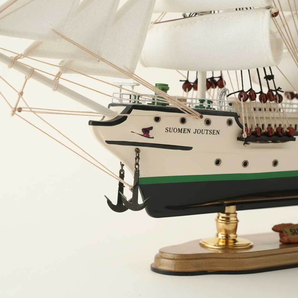 Suomen Joutsen ship model bow close-up – white hull with green stripe, black anchor chain, name lettering, rope rigging and brass display stand