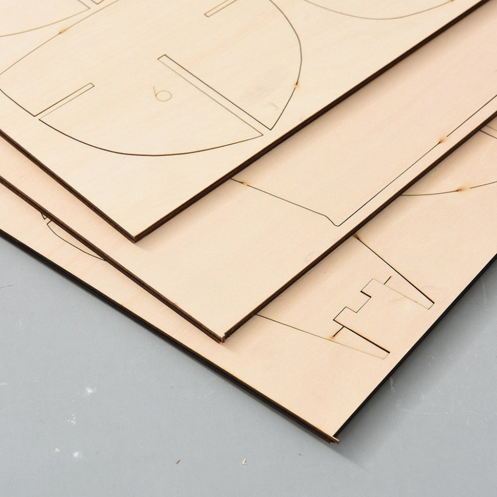 Close-up of laser-cut basswood hull frame sheets for Mayflower 1620 wooden ship model kit, showing precision-cut plank and frame components