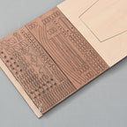 Close-up of laser-cut basswood hull frame sheets for Mayflower 1620 wooden ship model kit, showing precision-cut plank and frame components