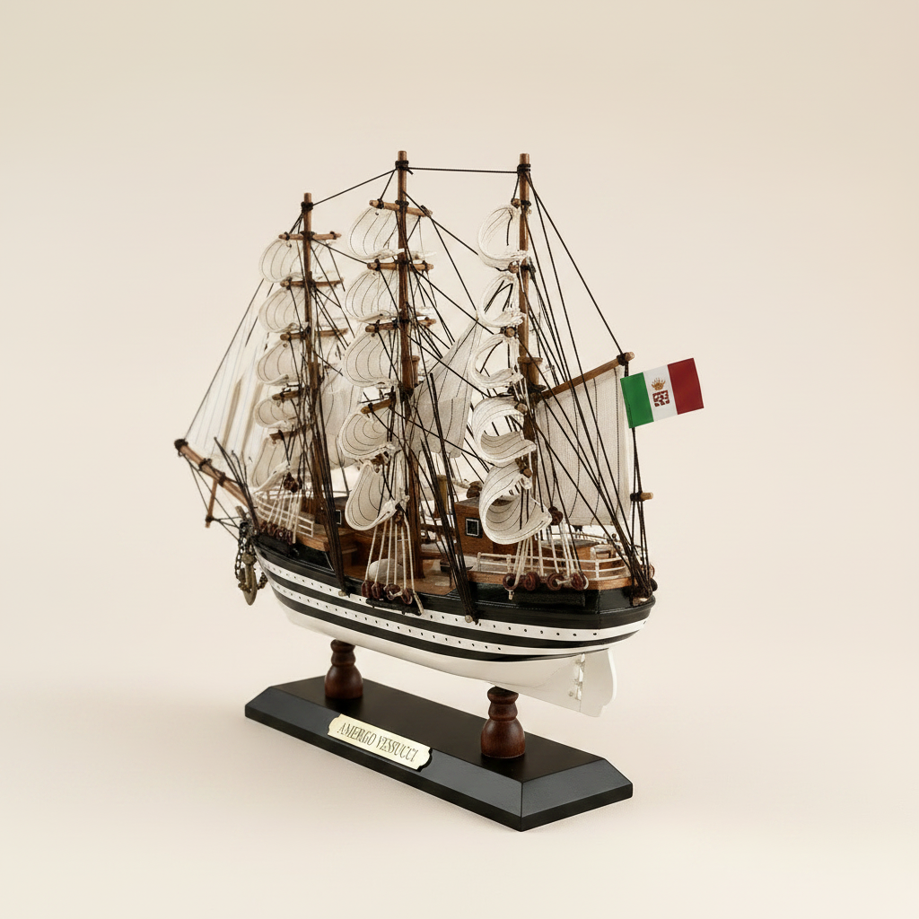 Rear 3/4 angle of Amerigo Vespucci Italian Navy tall ship wooden model on cream background, showing three-mast rigging structure, white square-rigged sails, Italian Navy flag at stern, black-and-white striped hull, and black display base with gold AMERIGO VESPUCCI nameplate

