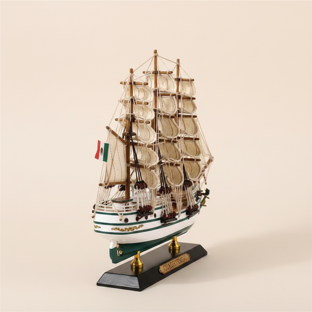 Front bow-on view of Cuauhtémoc Mexican Navy tall ship wooden model on cream background, showing three-mast full sail configuration, rope rigging, white hull with teal-green waterline, Mexican flag, gold decorative hull trim, and black display base with gold Cuauhtemoc nameplate