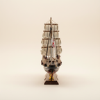 Modello in legno del clipper britannico Cutty Sark 1869, vista frontale di prua, con tre alberi, vele quadre bianche, scafo blu navy e bandiera Union Jack