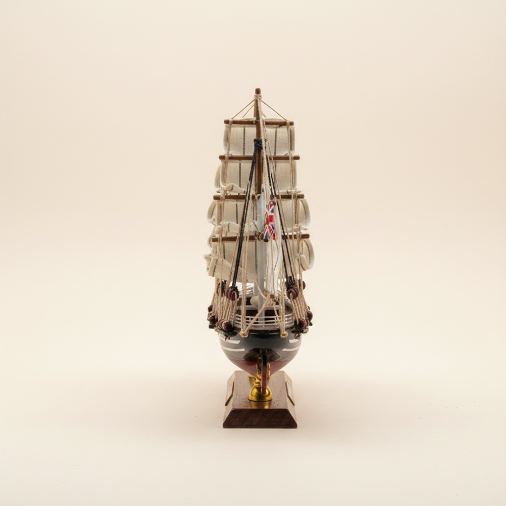 Modello in legno del clipper britannico Cutty Sark 1869, vista frontale di prua, con tre alberi, vele quadre bianche, scafo blu navy e bandiera Union Jack