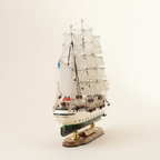 Suomen Joutsen wooden ship model rear view – stern details, white hull with green-black stripe, full sails, Finnish flag and brass display base