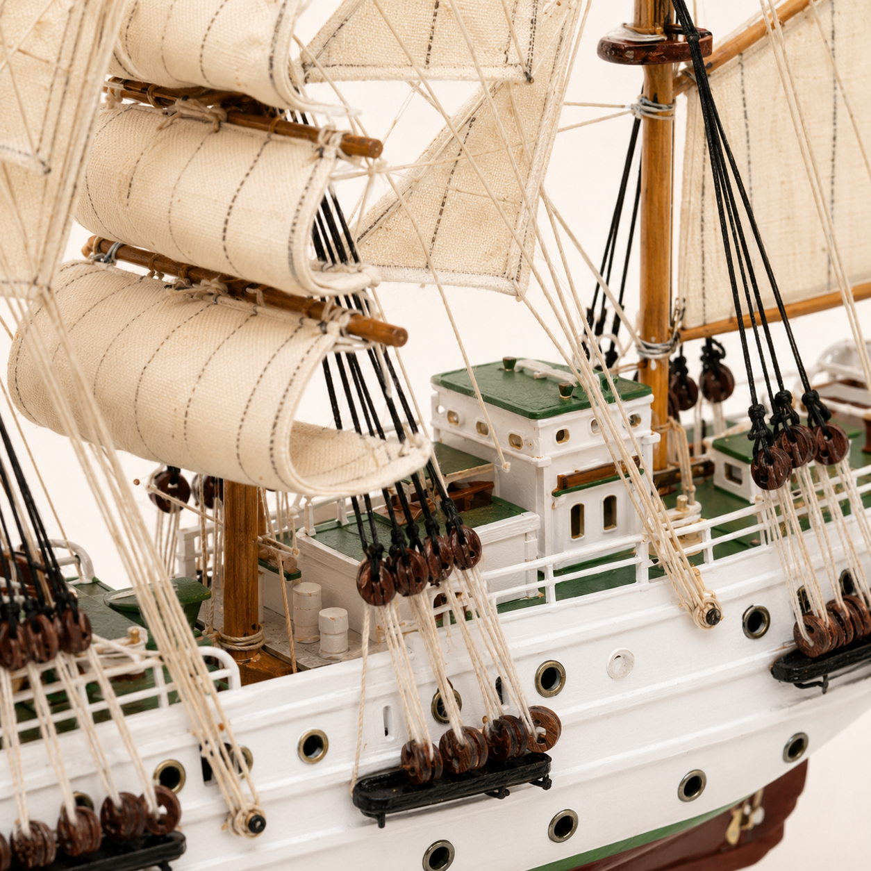 Close-up of the A.R.C. Gloria model ship deck, showing fabric sail stitching, wooden masts, rope rigging, pulleys, railings and handcrafted cabin details.