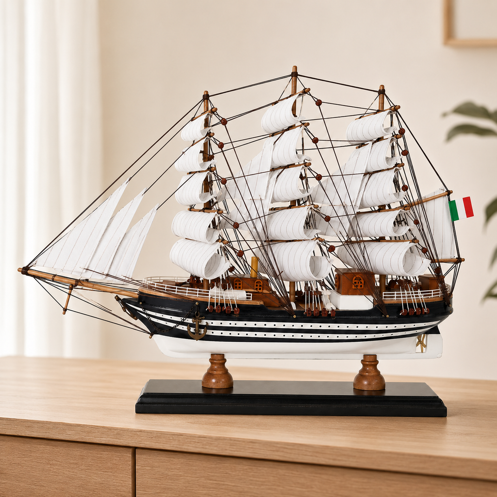 Amerigo Vespucci wooden tall ship model displayed on a light wood cabinet, featuring layered white sails, detailed dark rigging, black-and-white striped hull, Italian flag and black display base.