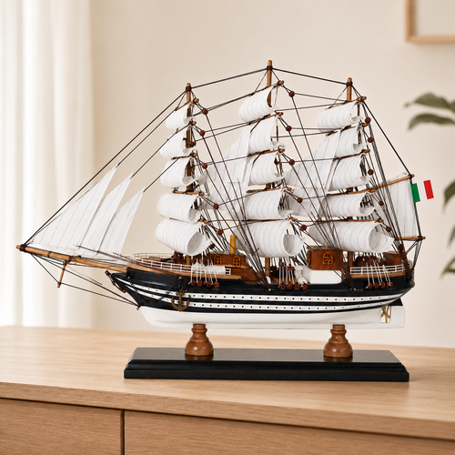 Amerigo Vespucci wooden tall ship model displayed on a light wood cabinet, featuring layered white sails, detailed dark rigging, black-and-white striped hull, Italian flag and black display base.