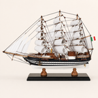 Side view of the Amerigo Vespucci wooden sailing ship model featuring three masts, layered white sails, black-and-white hull stripes, wooden deck cabins and black display stand.