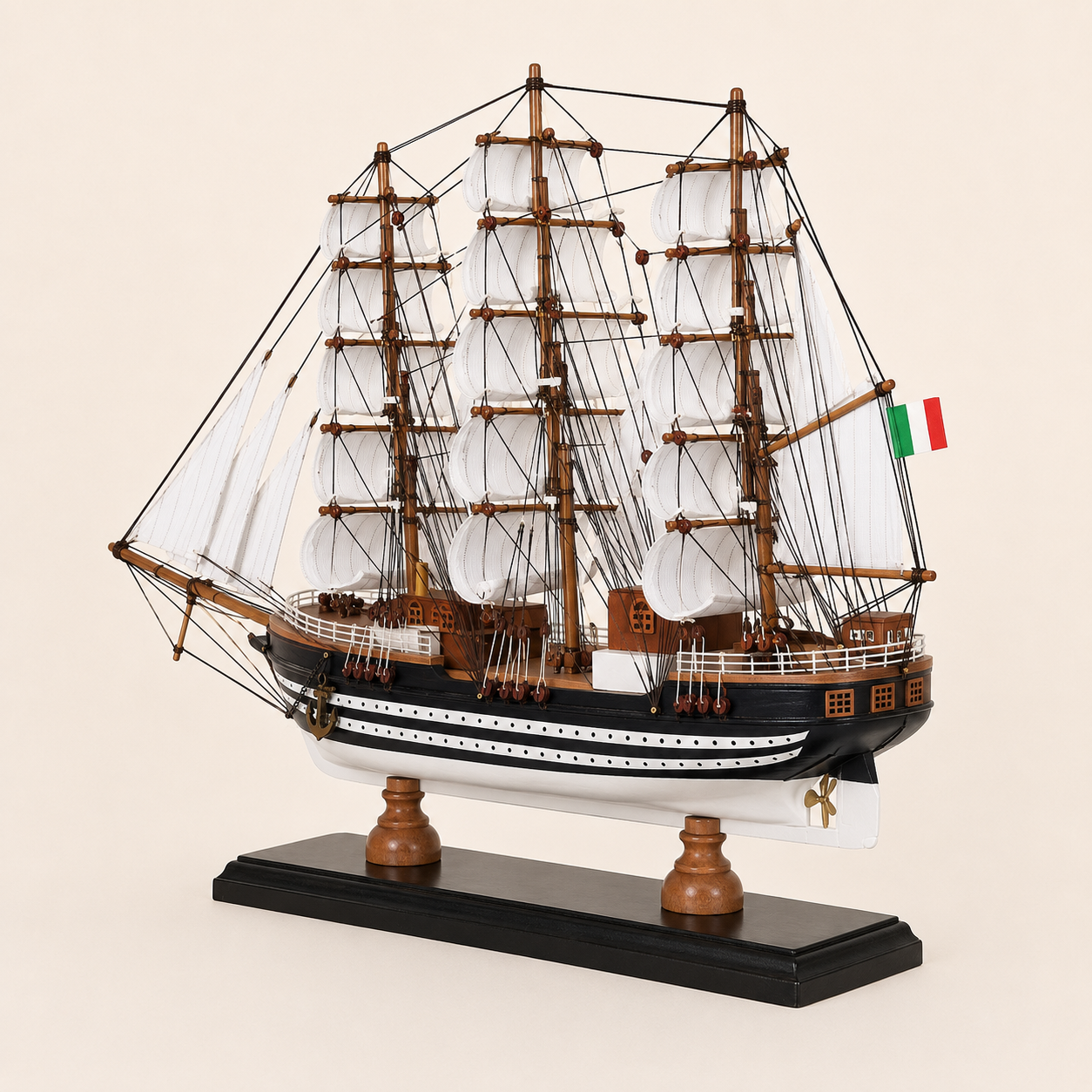 Rear 45-degree view of the Amerigo Vespucci tall ship model showing the stern, rear deck cabins, Italian flag, white sails, intricate rigging and black wooden base.