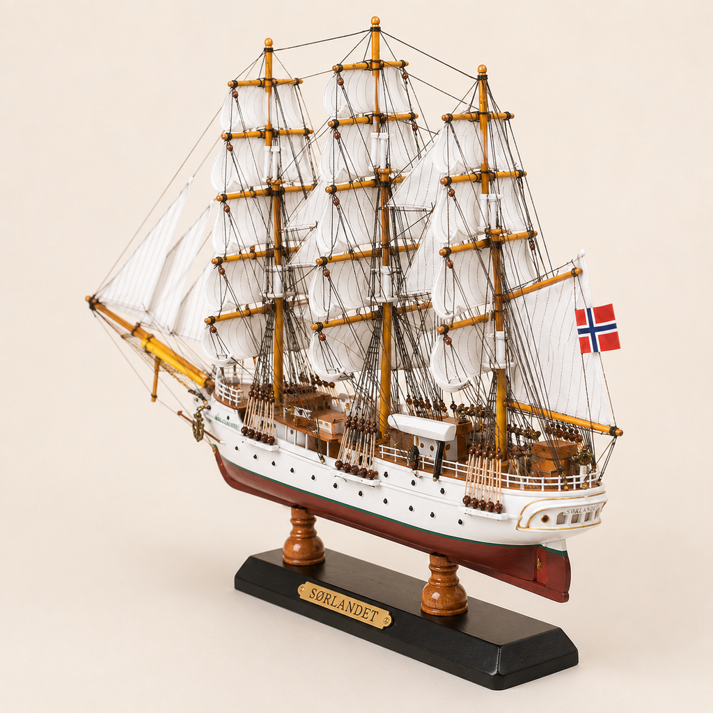 Rear 45-degree view of the Sørlandet wooden tall ship model showing the stern, rear deck, Norwegian flag, white sails, detailed rigging and black presentation base.