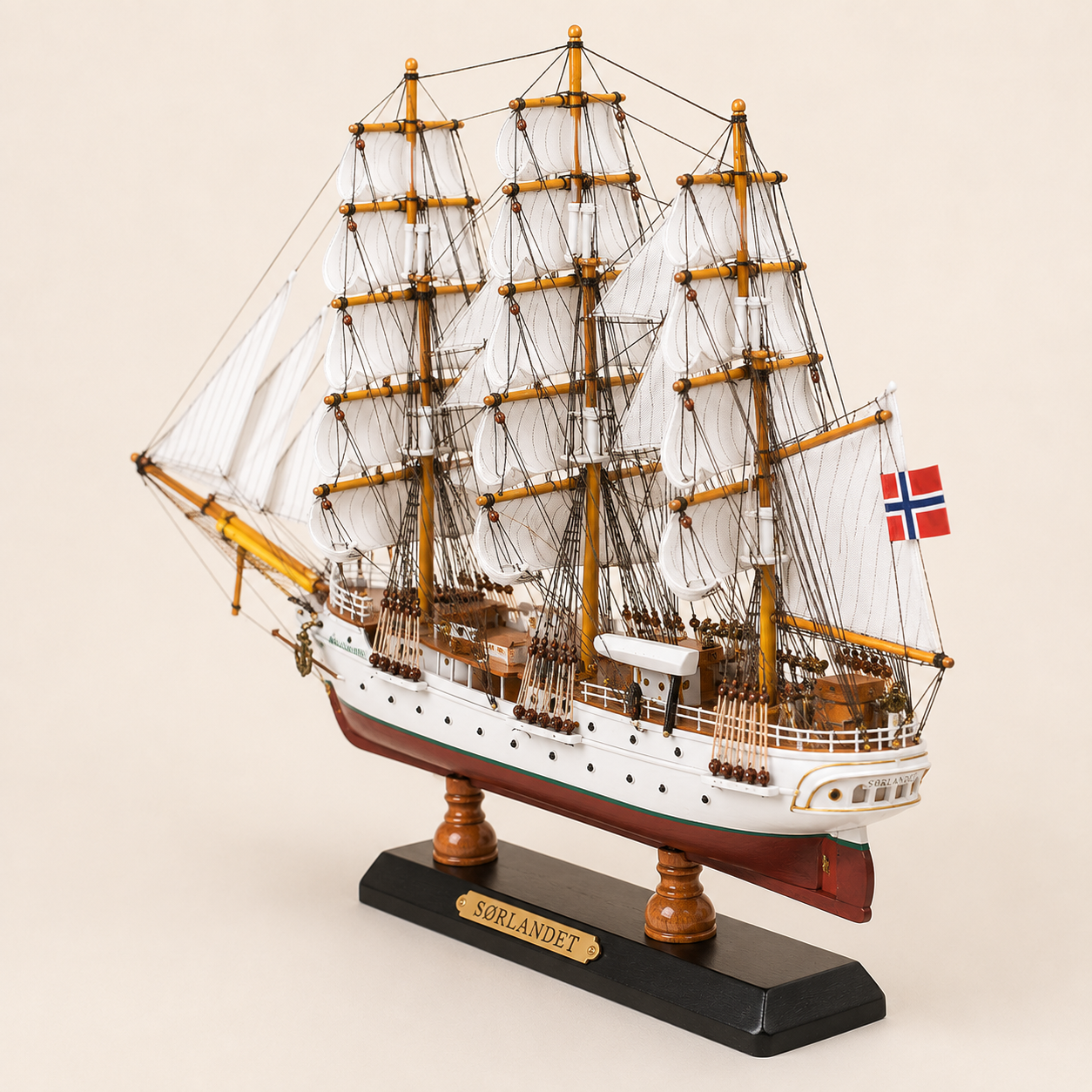Rear 45-degree view of the Sørlandet wooden tall ship model showing the stern, rear deck, Norwegian flag, white sails, detailed rigging and black presentation base.