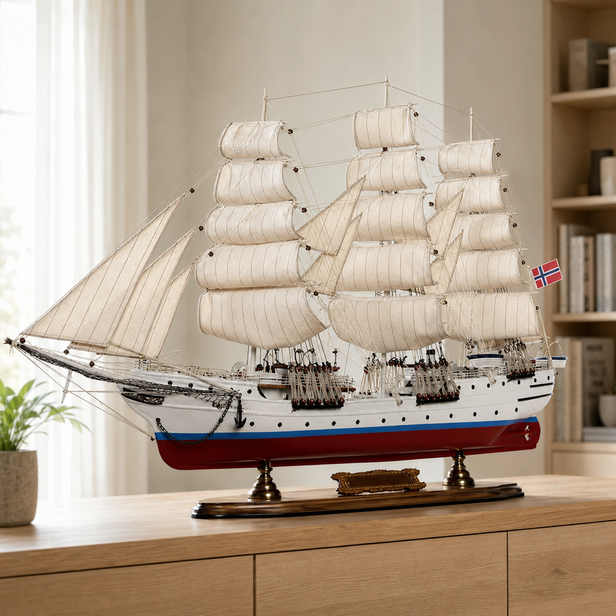Large handcrafted Norwegian tall ship model displayed on a wooden cabinet in a modern interior, featuring cream fabric sails, detailed rigging, white hull, red lower hull and Norwegian flag.