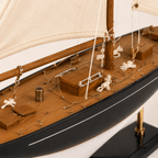 Modello di barca a vela in legno, dettaglio ravvicinato, con alberi, vele, scafo e dettagli del sartiame