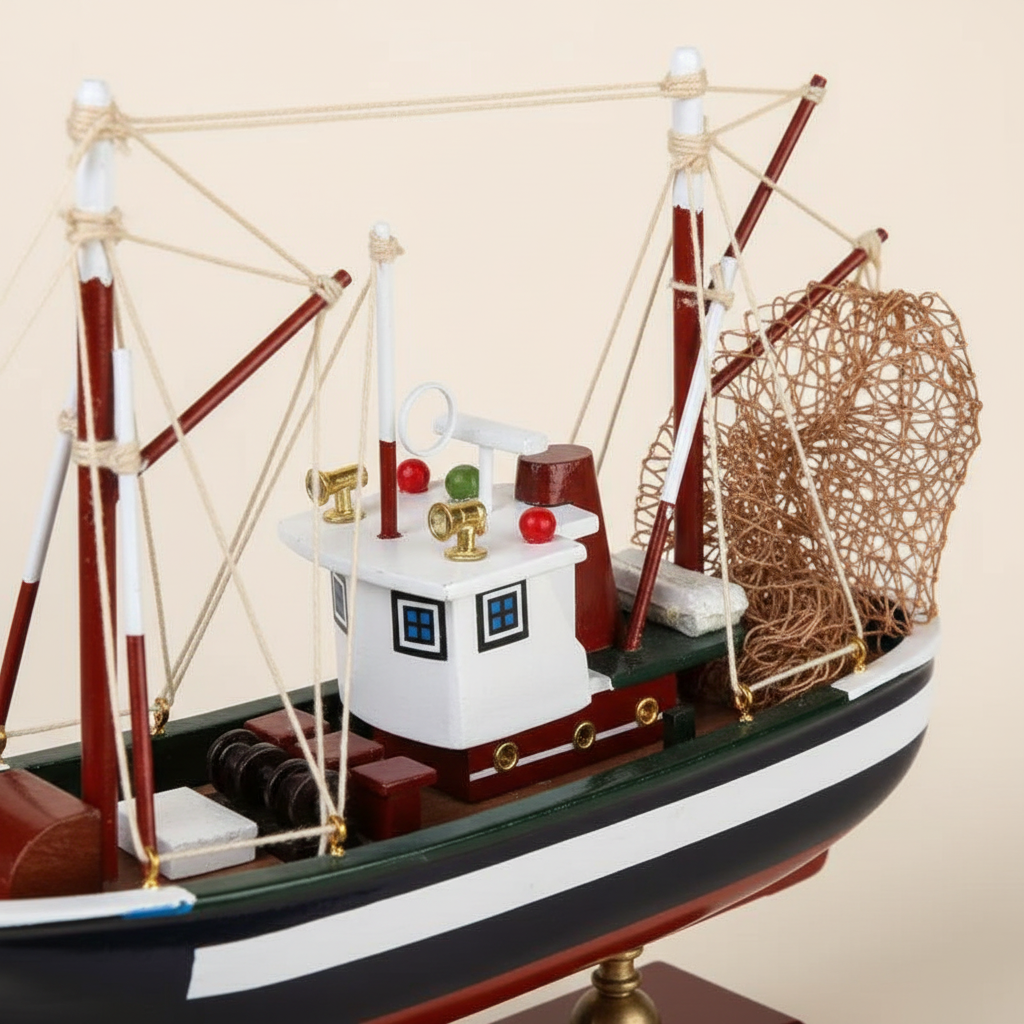 Close-up detail of American shrimp boat wooden model – white painted wheelhouse with red signal lights, red wooden outrigger booms, white rope rigging connections, and rolled metal fishing net, handcrafted nautical collectible
