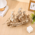 Wooden ship model on a wooden surface with decor items around