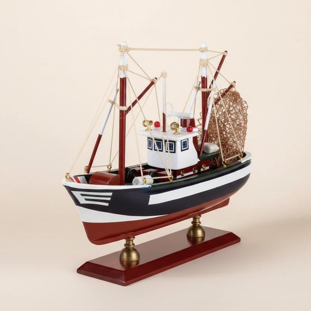 American shrimp boat wooden model front 3/4 view – navy blue hull with white horizontal stripe, white painted wheelhouse with red signal lights, red outrigger booms, white rope rigging, rolled metal fishing net at stern, mahogany display base with brass ball feet, cream white background