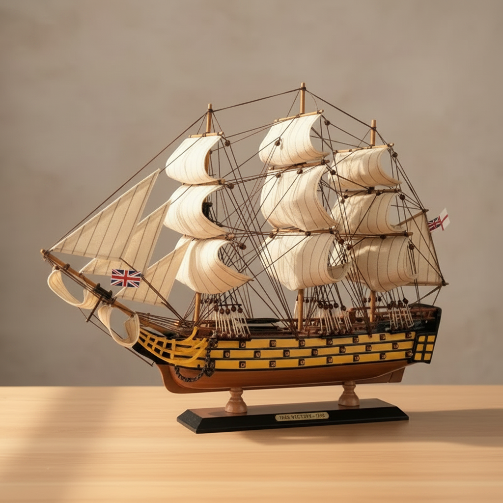 HMS Victory wooden ship model on wooden desk – handcrafted British warship collectible with white sails and yellow-black hull