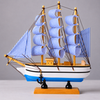 Model ship with blue and white striped sails on a gray background