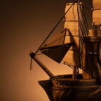 Close-up of the bowsprit and triangular foresail on a handcrafted wooden sailboat model, showing rope rigging detail